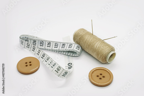 Sewing accessories. Threads, needles, tape measure, buttons, pins. Close-up. White background. Hobby. Needlework. Sewing