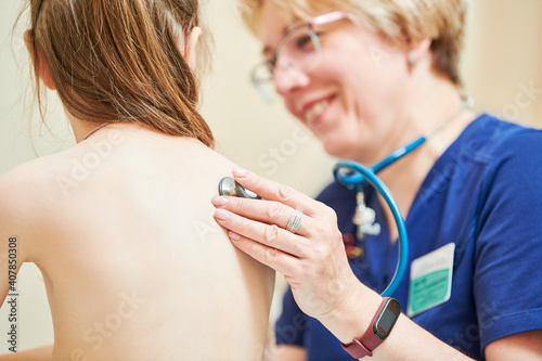 Photography Child pediatrician. Female doctor examining little girl