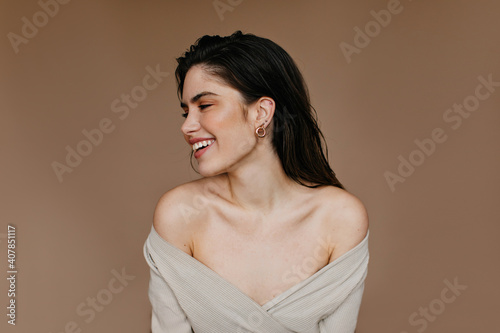 Appealing girl smiling in studio. Indoor photo of blissful female model with black hair. photo