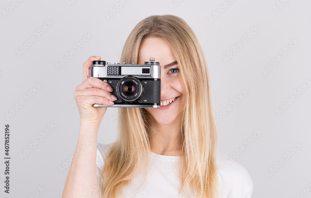 Happy smiling young girl holding camera and taking photos Happy smiling young girl holding camera and taking photos