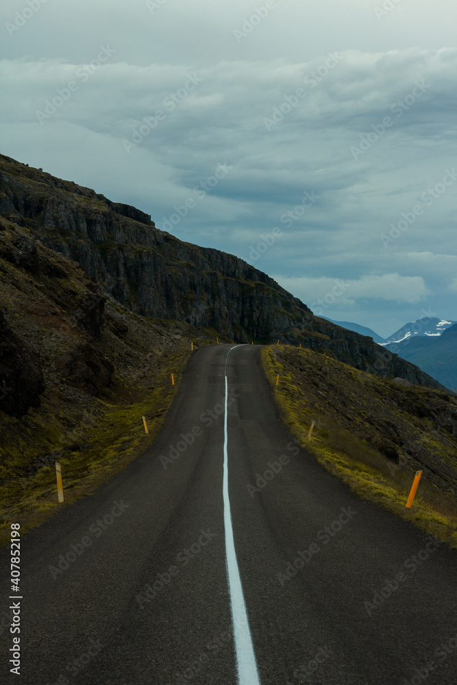 A long road leading through big mountains. Icelandic road 1 leading through the eastern fjords.