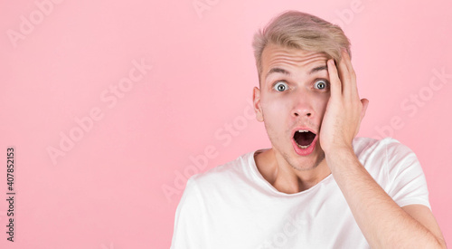Surprised man wearing white undershirt over pink background