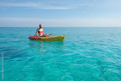girl paddles a kayak in the turquoise waters, vacation in Cuba © nexusby