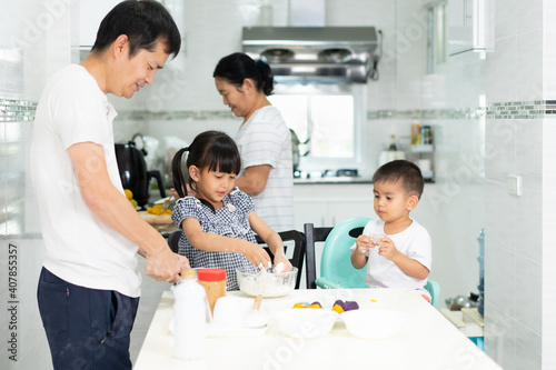 Multigeneration people in the family are happy to prepare and cooking the dessert in the kitchen with happy moment, concept of practical life learning for child through home based activity.