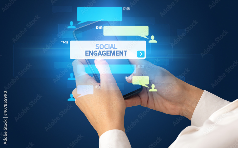 Female hand typing on smartphone with SOCIAL ENGAGEMENT inscription, social networking concept