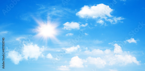 Sunny day background  blue sky with cumulus clouds and summer or spring sun as nature background.