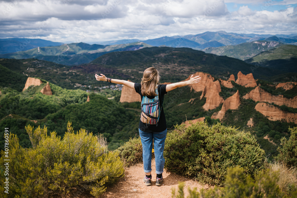 Unrecognizable woman looking at the mountains with open arms