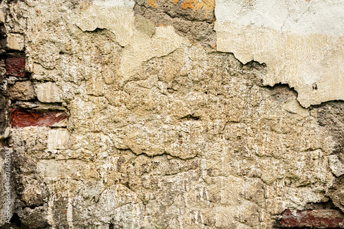 Brown shabby building facade with damaged plaster, old brick wall texture, abstract background, copy space