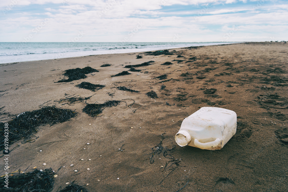 large plastic bottle washed up on a beach. large plastic bottle washed up on a beach.