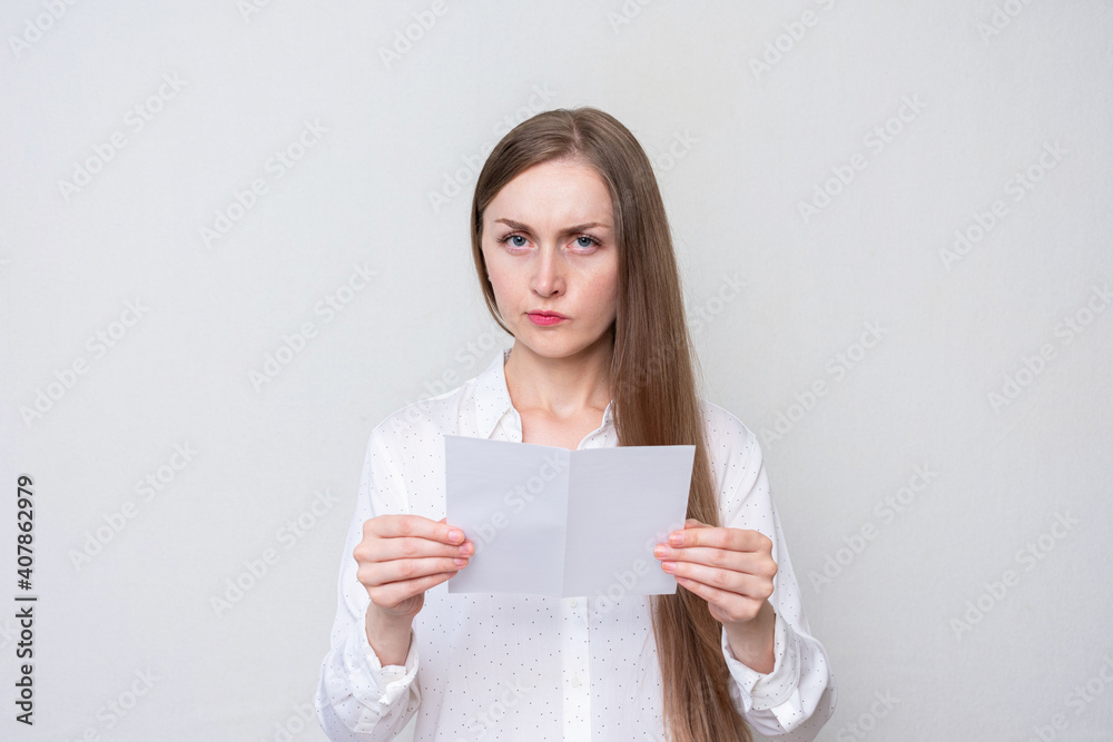 Dissatisfied woman reading a letter, white background Dissatisfied woman reading a letter, white background