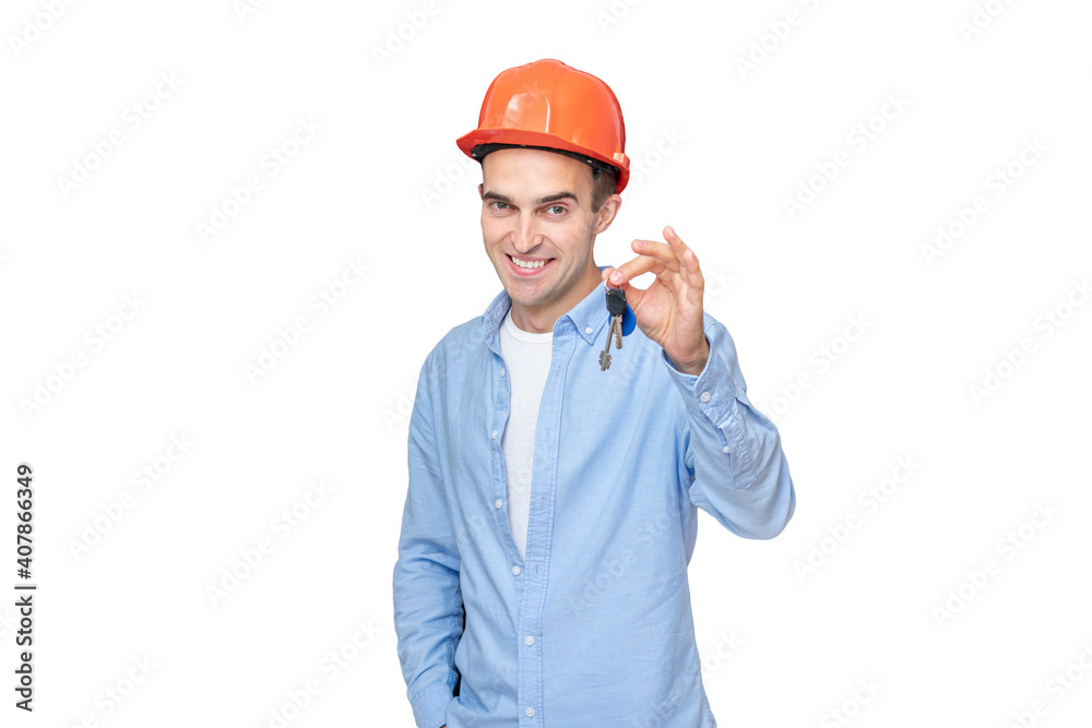 Cheerful builder in helmet shows keys, focus on the key hand, isolated Cheerful builder in helmet shows keys, focus on the key hand, isolated