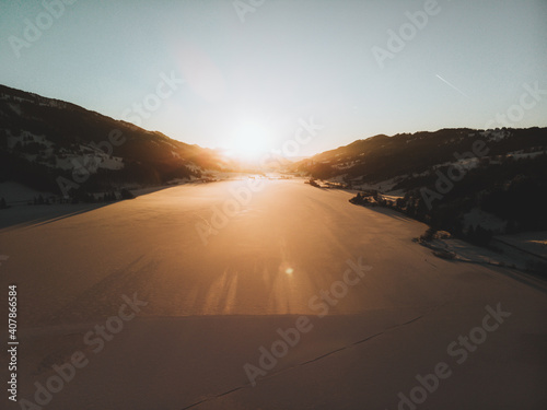 Fototapeta Naklejka Na Ścianę i Meble -  Großer Alpsee im Winter mit Eis während dem Sonnenuntergang
