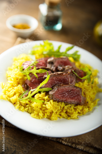 Rice with beef steak and arugula