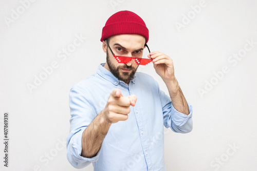 Man with the fancy glasses threatens you and points his finger at the camera, portrait, white background