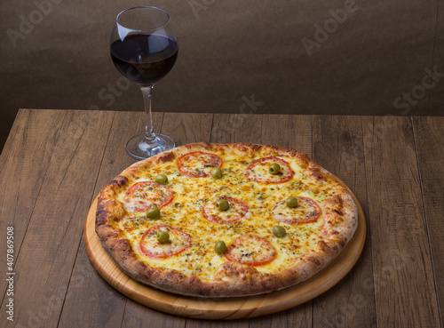 ricardo fernando franca junior pizza mussarela muçarela mucarelHigh angle photo highlighting the details of a mozzarella cheese pizza with red tomato slices. A glass of red wine on the right.