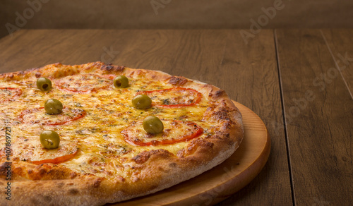 ricardo fernando franca junior pizza mussarela muçarela mucarelMozzarella cheese pizza with slices of red tomatoes on a wooden board. Horizontal gastronomic photography with ample spaces for texts. photo