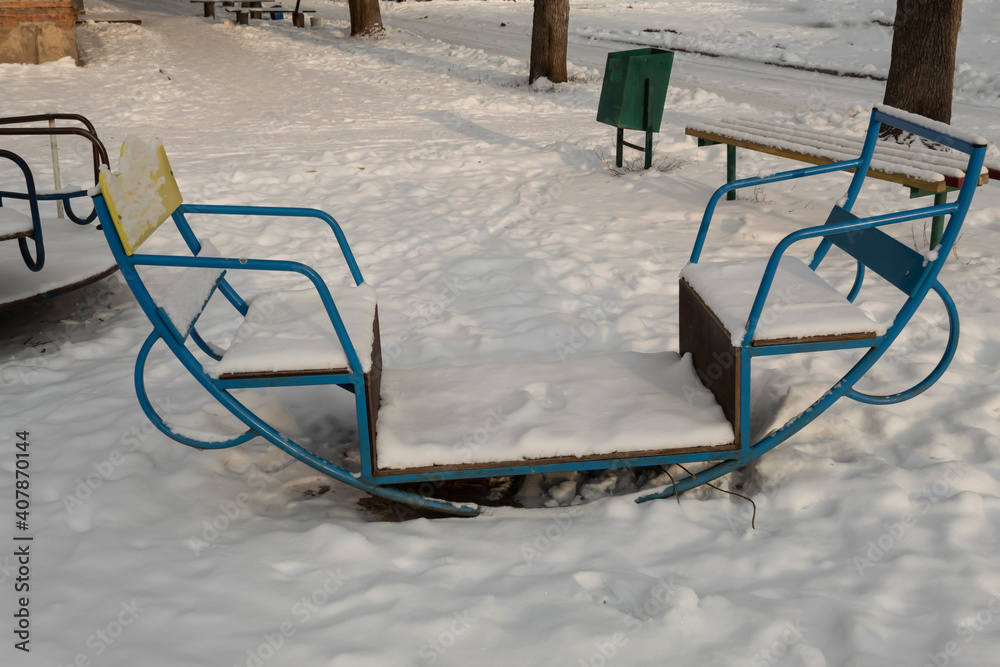 Children's swing on the playground in winter in the snow. Children's swing on the playground in winter in the snow.