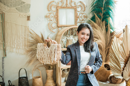 a businesswoman in a blazer carries a woven bag as she stands against a multicraft background in a craft shop photo