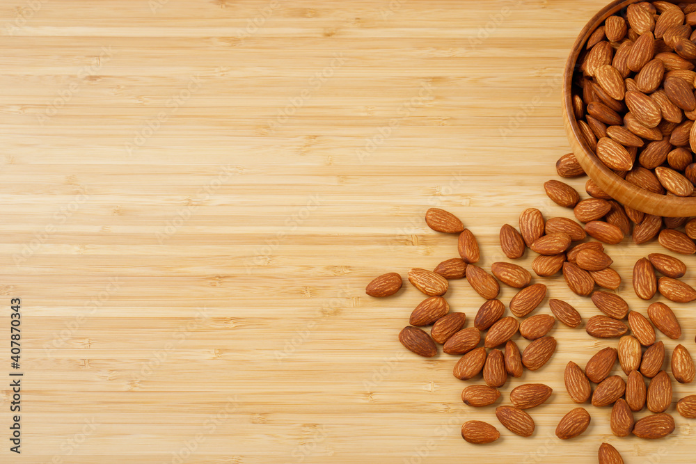 Organic almond nut raw peeled in bowl on wooden table, top view. Healthy snack or for vegetarians. Organic almond nut raw peeled in bowl on wooden table, top view. Healthy snack or for vegetarians.