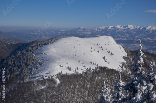 Osnica in winter. Snow-covered landscape, sunny winter weather, in the background the High Tatras.Winter mountain scenery, photo