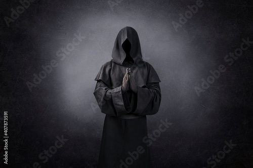 Ghostly figure praying in the dark photo