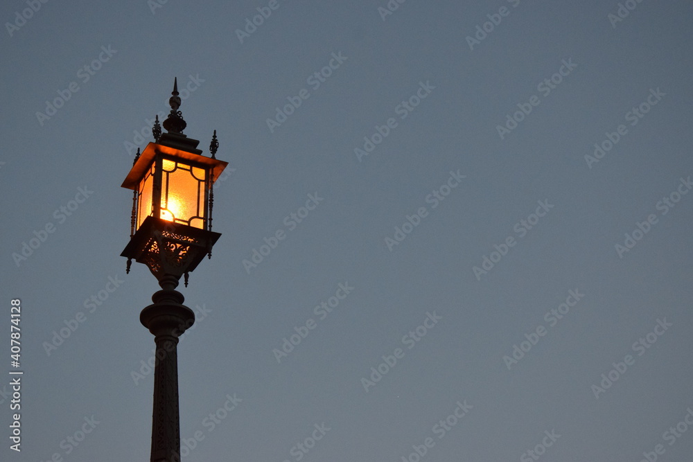 Foto de una farola encendida al anochecer.