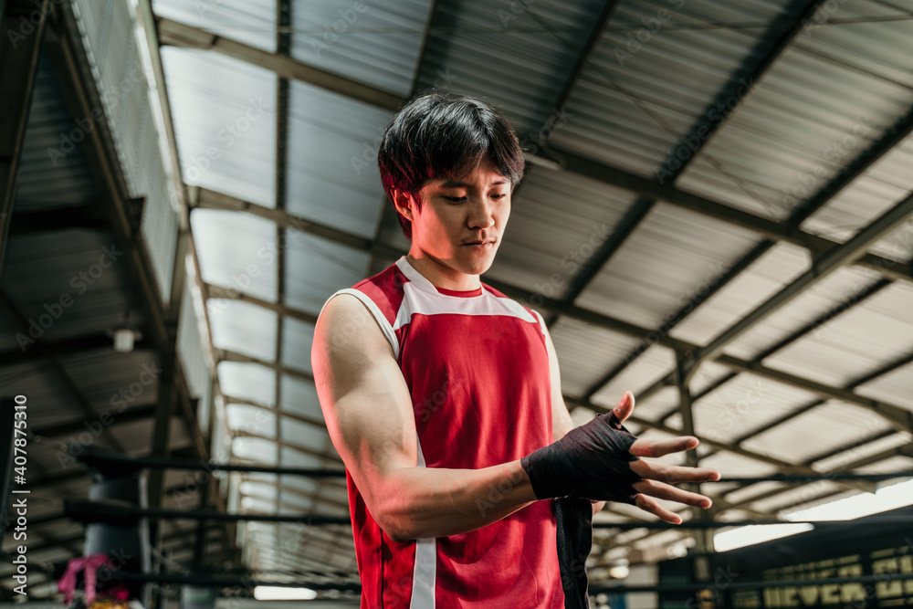 Fighting preparation. Cropped shot of a ripped man fighter wrapping his hands