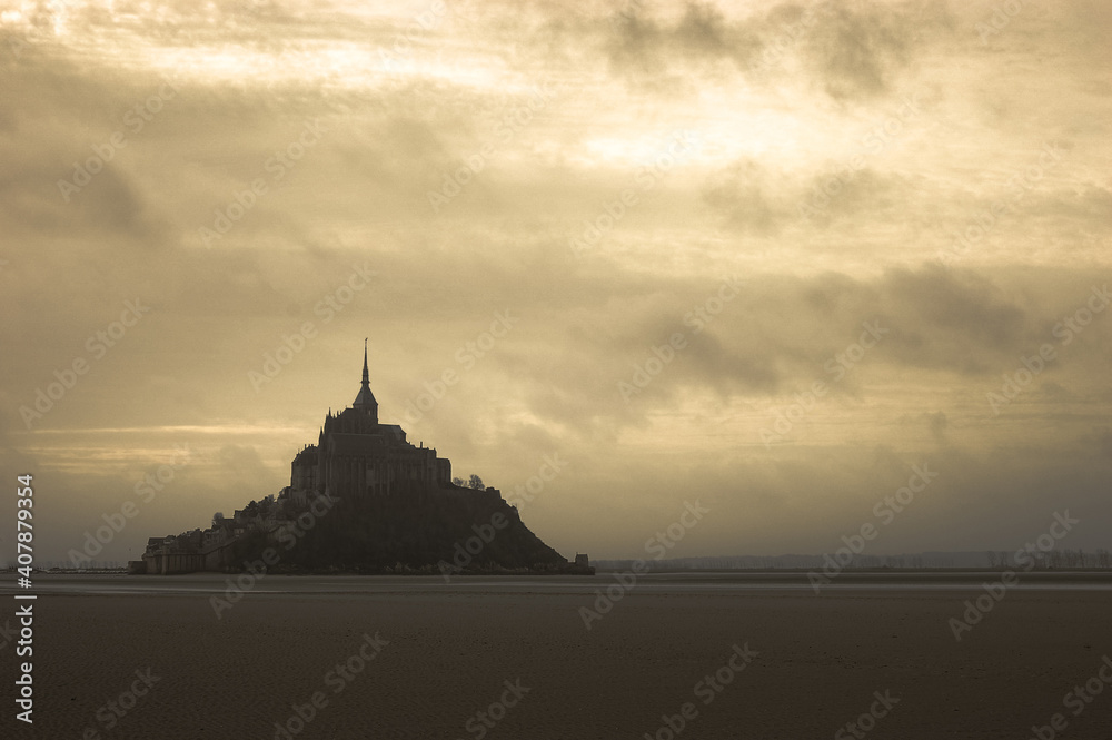 Silhouette en contre-jour du Mont Saint-Michel depuis la baie à marée basse