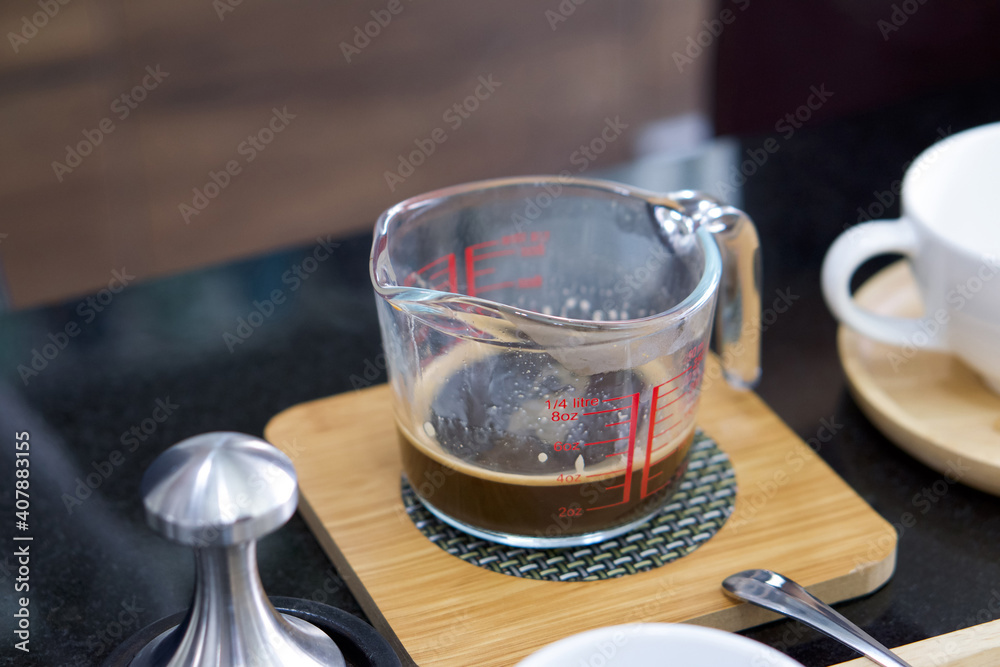 Closeup coffee in measuring cup on kitchen counter.