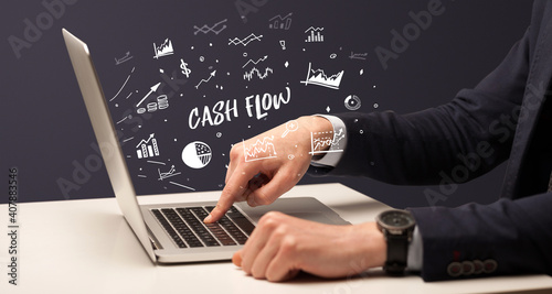 Businessman working on laptop with CASH FLOW inscription, modern business concept