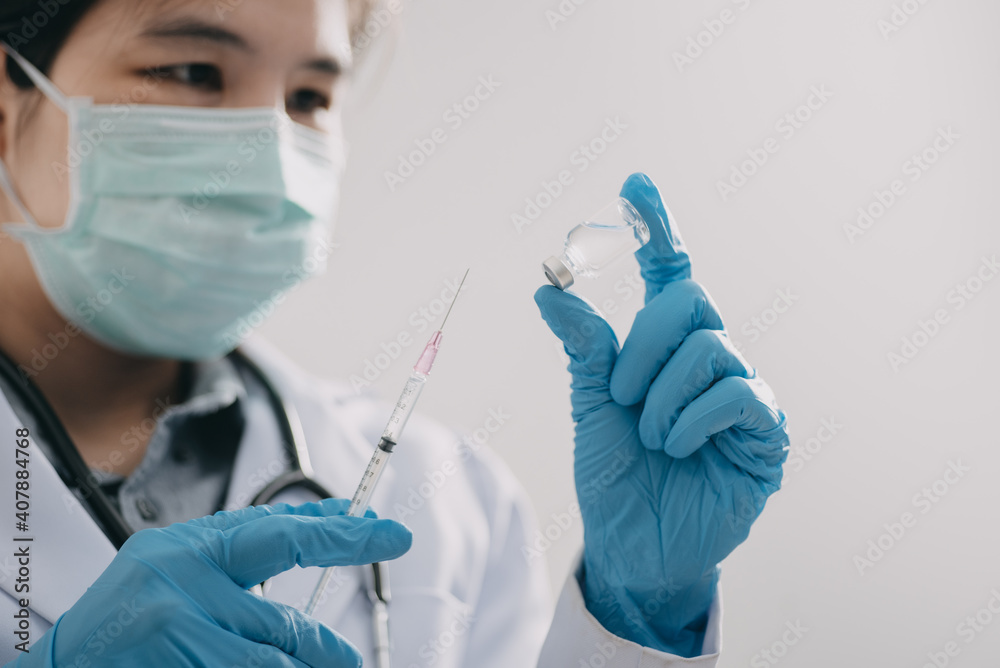 female doctor, scientist, researcher is showing syringe and vaccine vial with medication, closeup. Vaccination and immunization