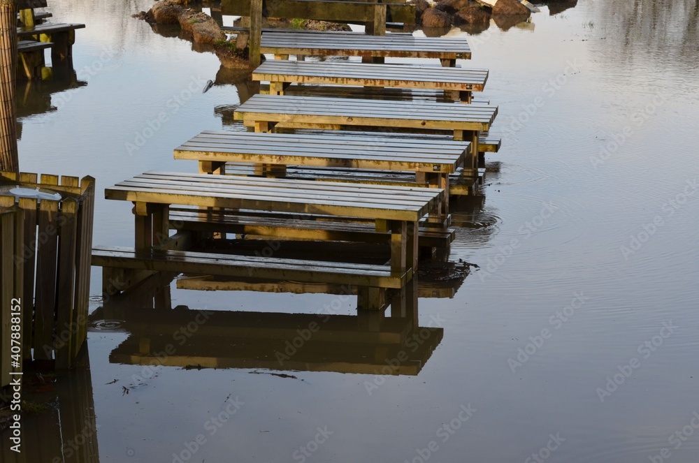 River in flood and its public benches and tables River in flood and its public benches and tables