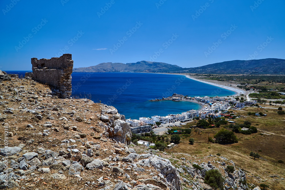 Ruins of a medieval fortress and the sea coast with the port and town on the island of Rhodes