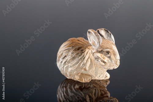 Fototapeta Naklejka Na Ścianę i Meble -  beautiful figurine of a hare made of topaz on a gray background