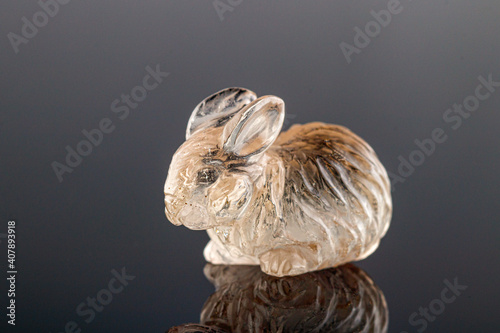 Fototapeta Naklejka Na Ścianę i Meble -  beautiful figurine of a hare made of topaz on a gray background