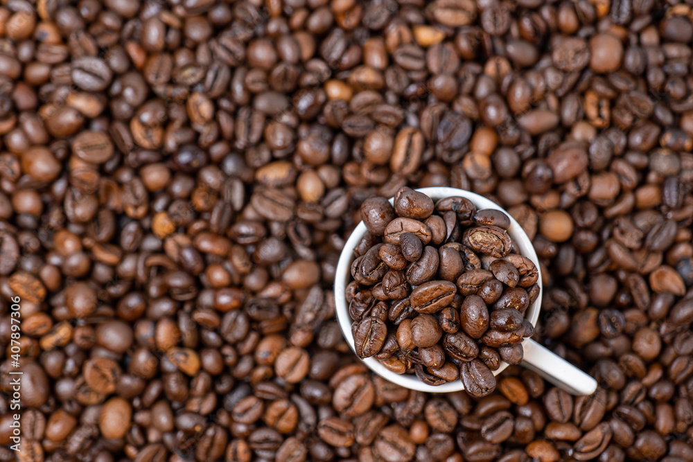 Fototapeta premium coffee beans close up and a cup full of coffee beans, top view