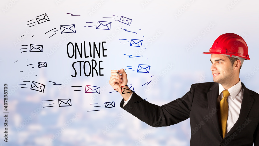 Handsome businessman with helmet drawing ONLINE STORE inscription, contruction sale concept Handsome businessman with helmet drawing ONLINE STORE inscription, contruction sale concept