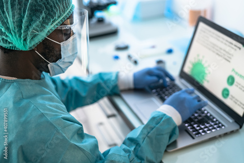 Fotografie Medical worker wearing personal protective equipment using computer inside clini