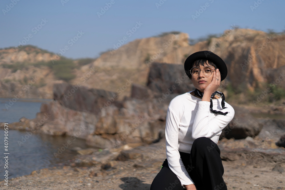 beautiful portrait of an indian girl wearing white dress and a black hat with a black hanky on tied her neck, captured on a white cloth with scenery in background. beautiful portrait of an indian girl wearing white dress and a black hat with a black hanky on tied her neck, captured on a white cloth with scenery in background.