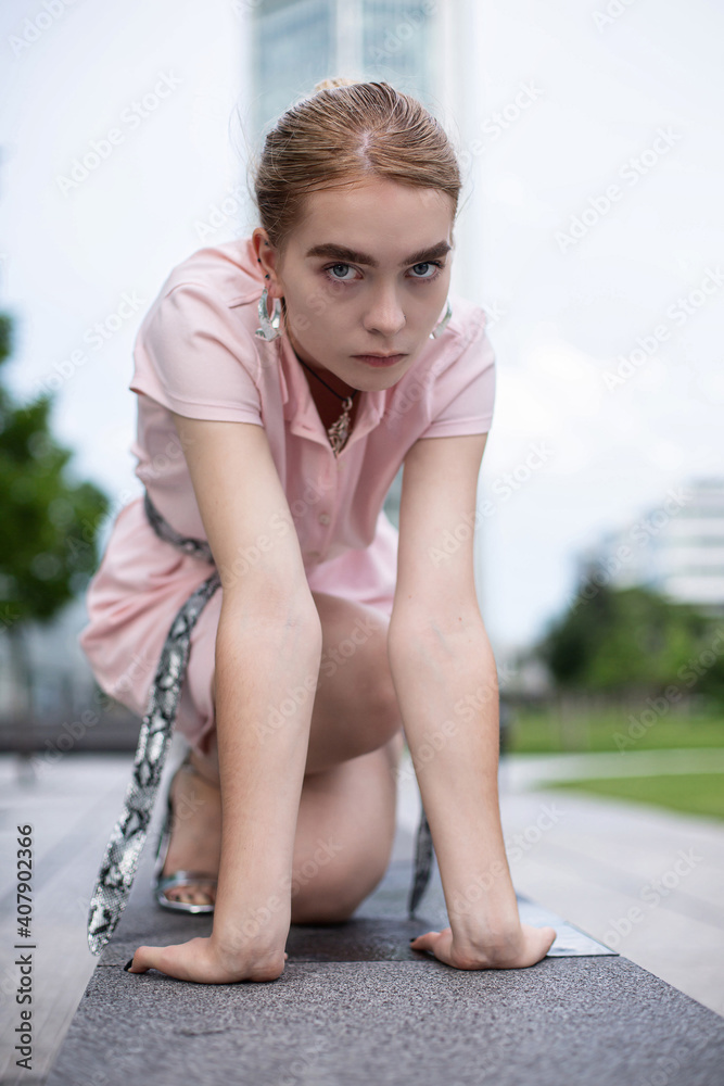 Young woman with blonde hair sitting in city Young woman with blonde hair sitting in city