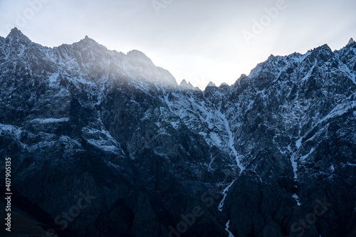 A Beam of Morning Sunshine from behind Snow Capped Mountains, Stepantsminda (Kazbegi), Georgia. photo