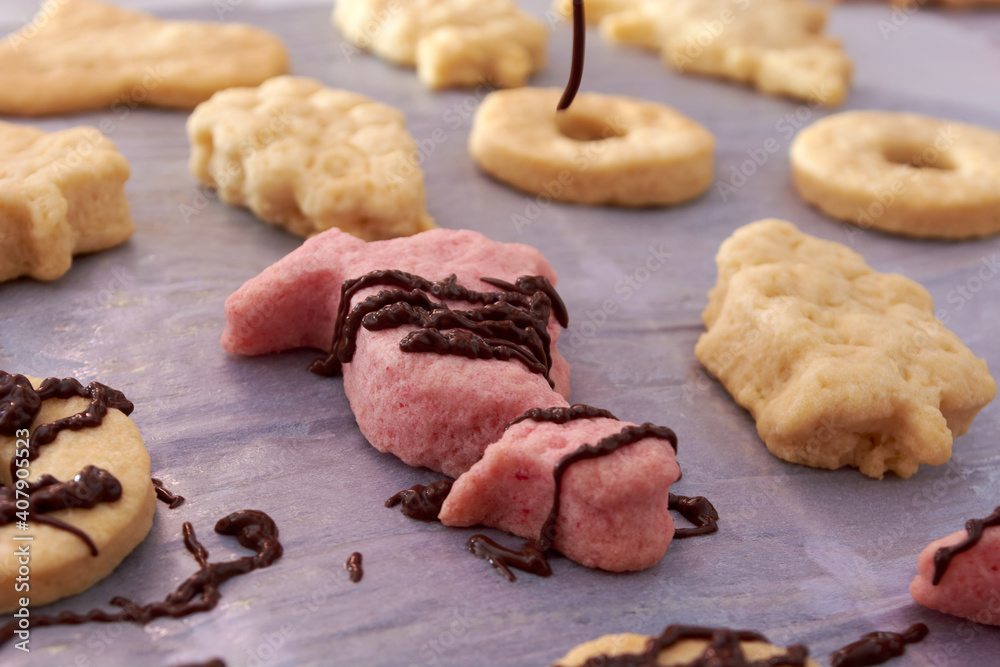 Pouring chocolate on just baked christmas cookies