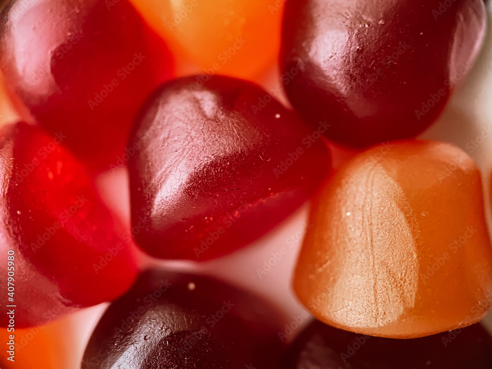 Close-up texture of red, orange and purple multivitamin gummies. Healthy lifestyle concept. Close-up texture of red, orange and purple multivitamin gummies. Healthy lifestyle concept.
