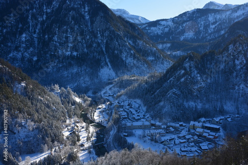 Small town in the valley surrounded by mountains in winter. Snowy landscape
