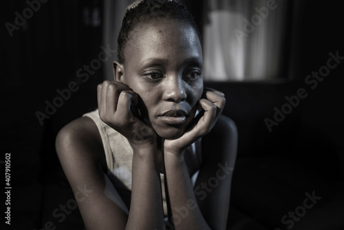 teen African American girl at night suffering depression - dramatic artistic portrait of young attractive sad and depressed black woman worried and upset alone in the dark