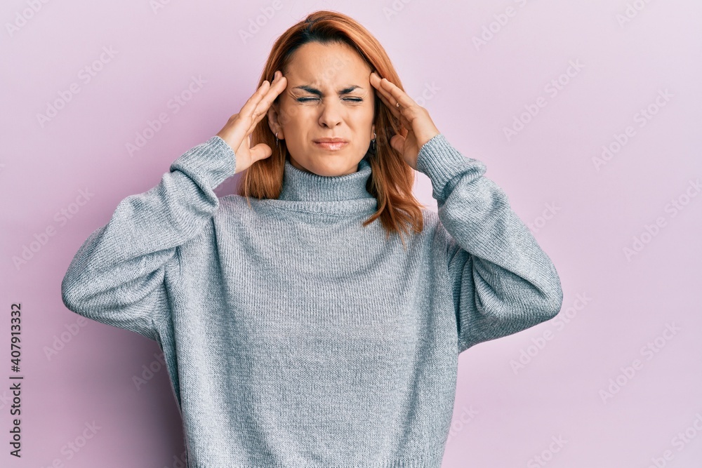 Hispanic young woman wearing casual turtleneck sweater with hand on head, headache because stress. suffering migraine. Hispanic young woman wearing casual turtleneck sweater with hand on head, headache because stress. suffering migraine.