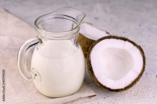 
Coconut milk in a small glass jug on a white background.
Lactose-free products concept.