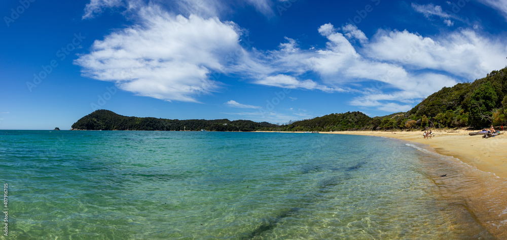 panoramic view of a tropical beach with turquoise water and white sand in abel tasman national park, new zealand