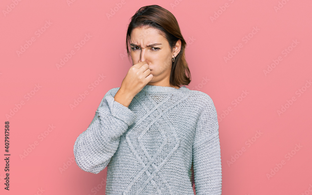 Young caucasian girl wearing casual clothes smelling something stinky and disgusting, intolerable smell, holding breath with fingers on nose. bad smell - obrazy, fototapety, plakaty 
