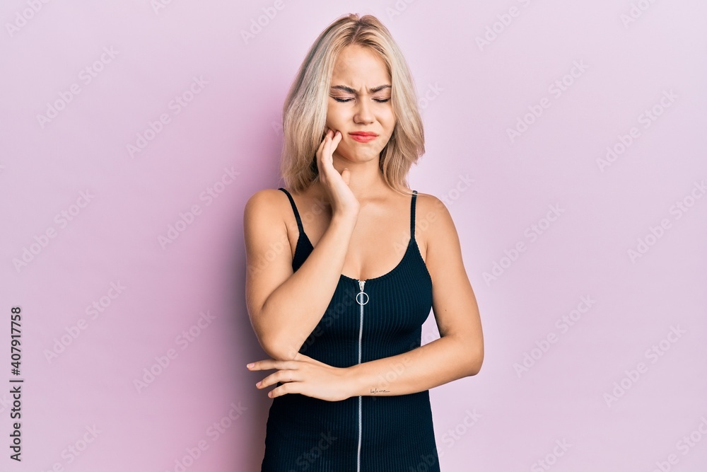 Beautiful caucasian blonde girl wearing sexy party dress touching mouth with hand with painful expression because of toothache or dental illness on teeth. dentist Beautiful caucasian blonde girl wearing sexy party dress touching mouth with hand with painful expression because of toothache or dental illness on teeth. dentist